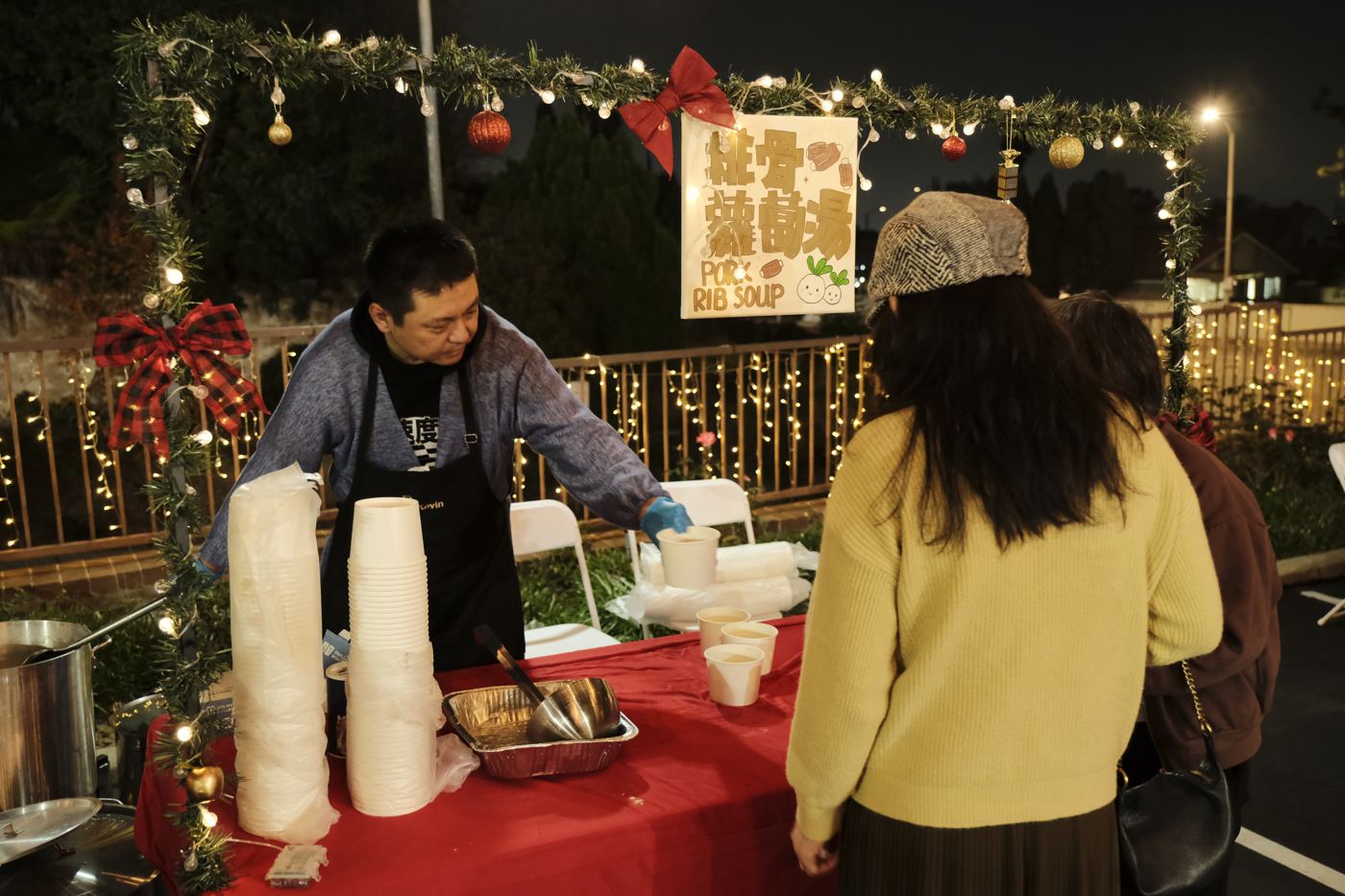 A volunteer preparing hot drinks at a booth